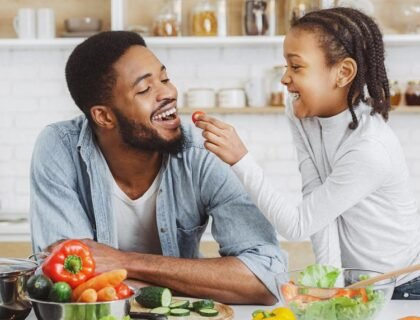 un père et sa fille qui lui proposent à manger